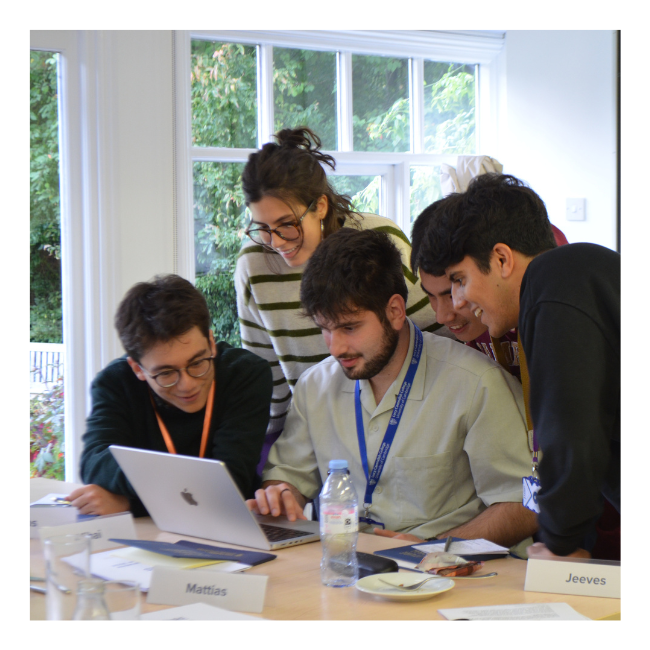 Students working together around laptop