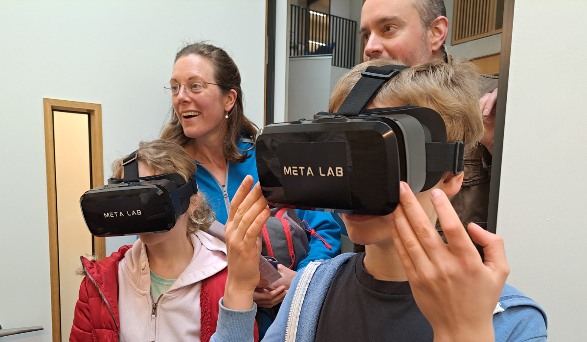 Two kids wearing VR head mount and their parents in the background