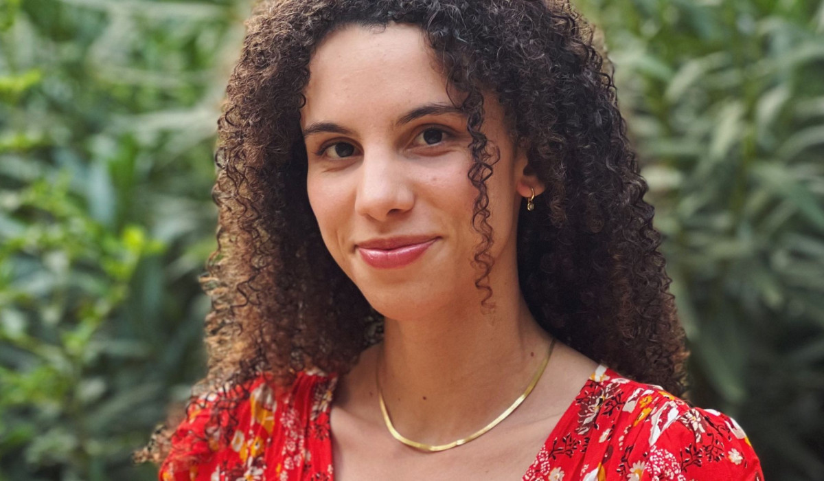 Imani Thompson's headshot. Green plants in the background